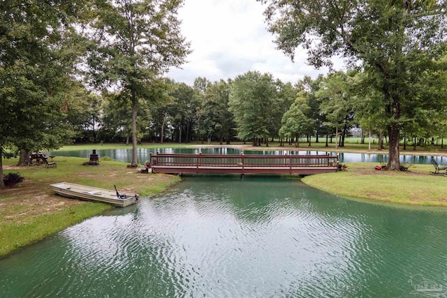 view of home's community with a deck with water view and a yard