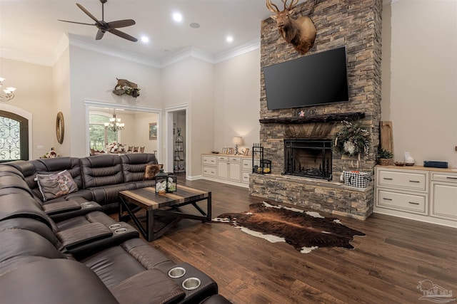 living room with ornamental molding, a fireplace, ceiling fan with notable chandelier, and dark hardwood / wood-style floors