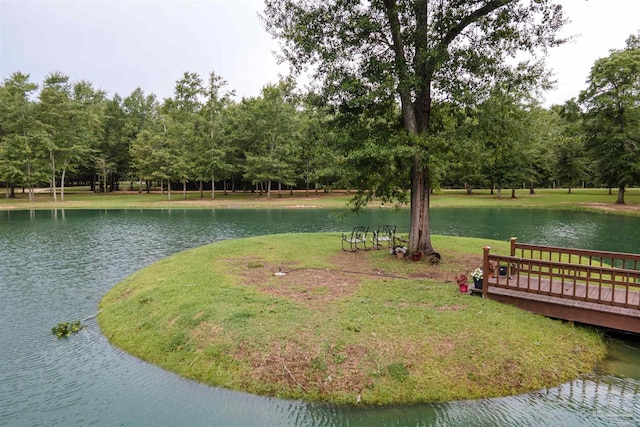 surrounding community featuring a water view and a lawn