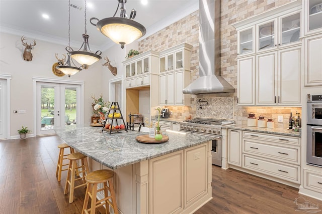 9180 Chumuckla Hwy, Pace, FL 32571 - kitchen with a kitchen breakfast bar, wall chimney range hood, ornamental molding, double oven range, and tasteful backsplash