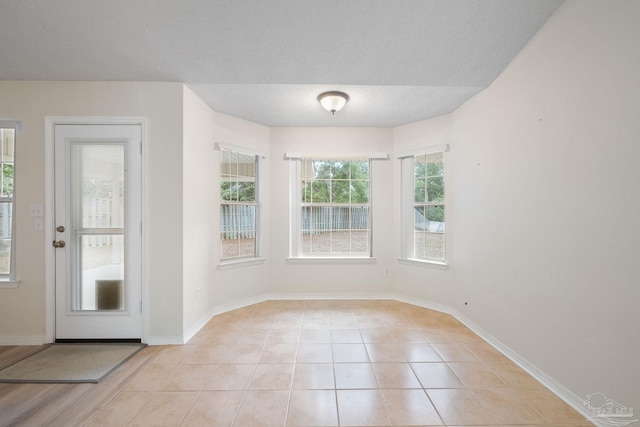 tiled spare room featuring a textured ceiling