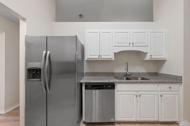 kitchen with white cabinets, light wood-type flooring, sink, and appliances with stainless steel finishes