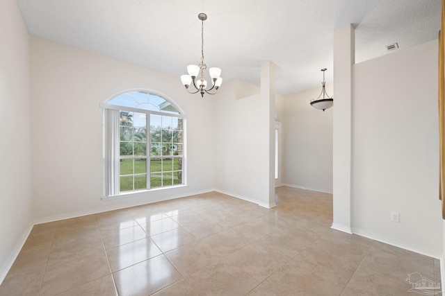 spare room featuring a notable chandelier, light tile patterned floors, and a textured ceiling