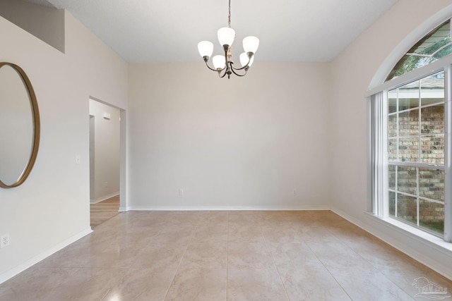 unfurnished room featuring a notable chandelier and light tile patterned floors