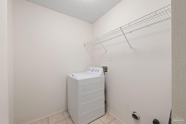 laundry area with light tile patterned floors, a textured ceiling, and washer / dryer