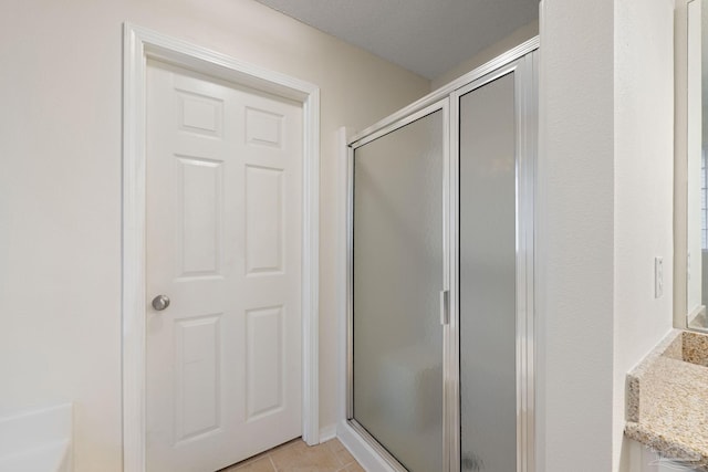 bathroom featuring tile patterned flooring, vanity, and a shower with door