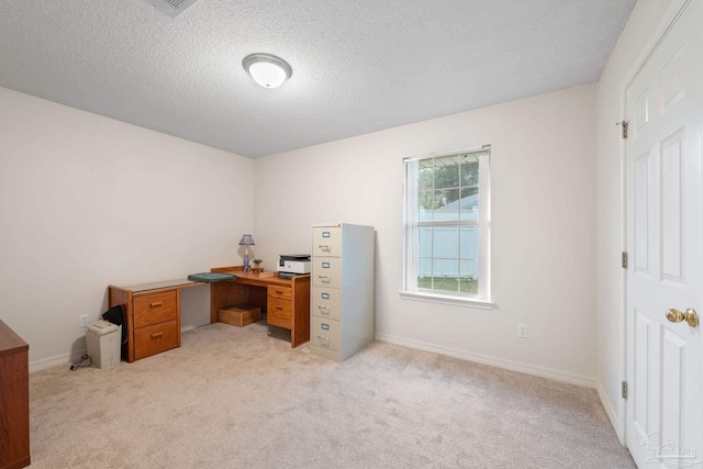 carpeted office space featuring a textured ceiling