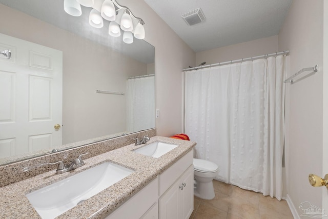 bathroom featuring tile patterned flooring, vanity, a textured ceiling, and toilet