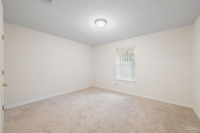 carpeted spare room with a textured ceiling