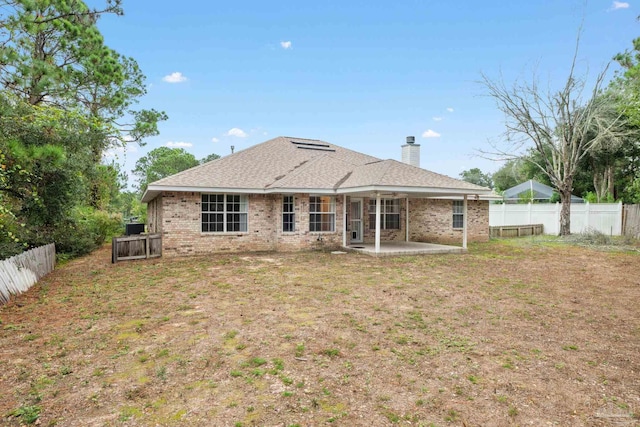 rear view of house featuring a yard and a patio