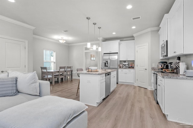 2275 Janet St, Navarre, FL 32566 - kitchen featuring stainless steel appliances, ornamental molding, light wood-type flooring, open floor plan, and a breakfast bar