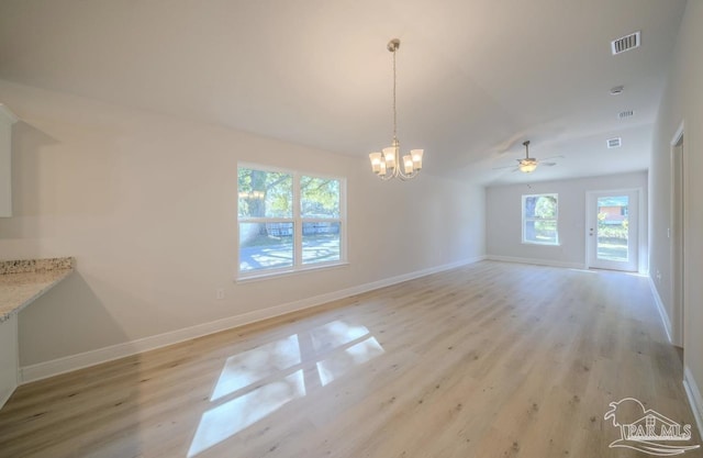 unfurnished dining area with ceiling fan with notable chandelier and light hardwood / wood-style floors