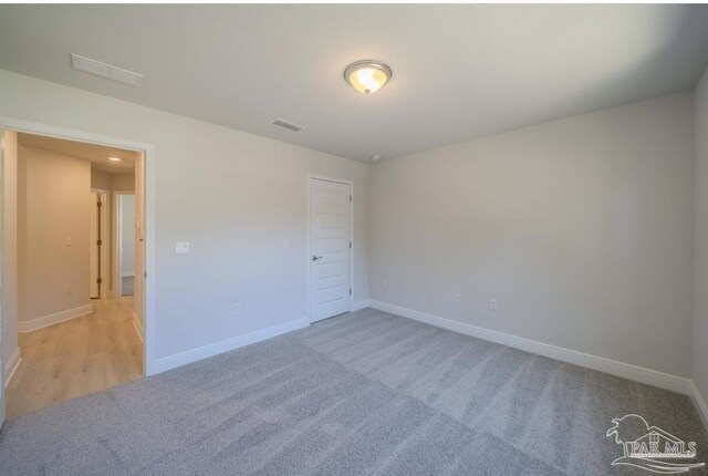 unfurnished room with light carpet