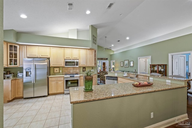 kitchen featuring visible vents, a ceiling fan, stainless steel appliances, light tile patterned floors, and vaulted ceiling