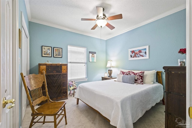 bedroom with carpet flooring, a textured ceiling, ceiling fan, and ornamental molding