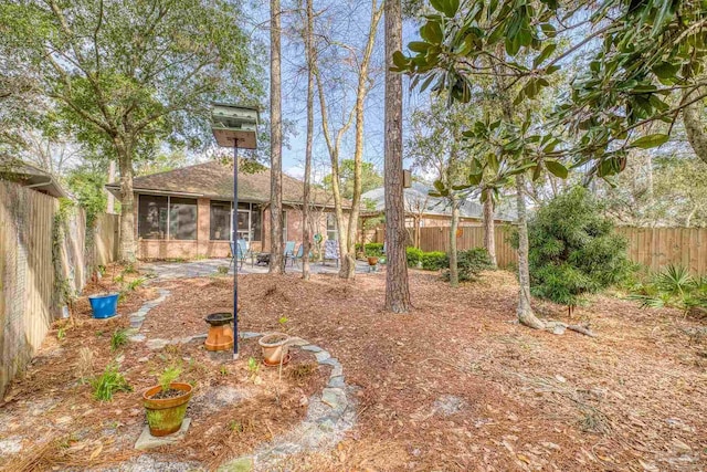 view of yard with a fenced backyard and a sunroom