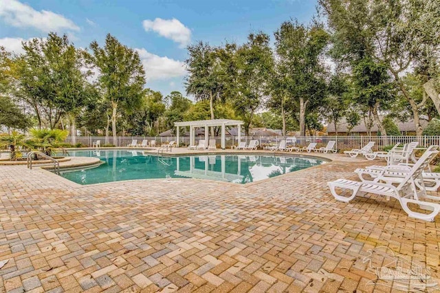 community pool featuring a patio area, fence, and a pergola