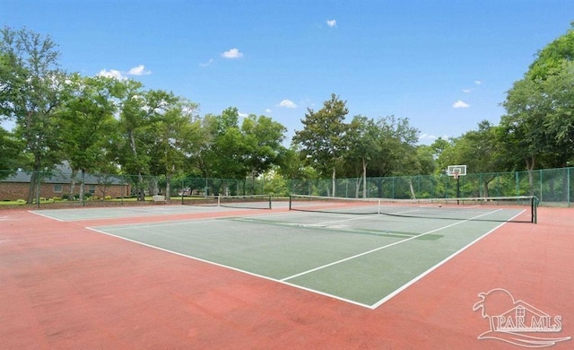 view of tennis court with community basketball court and fence