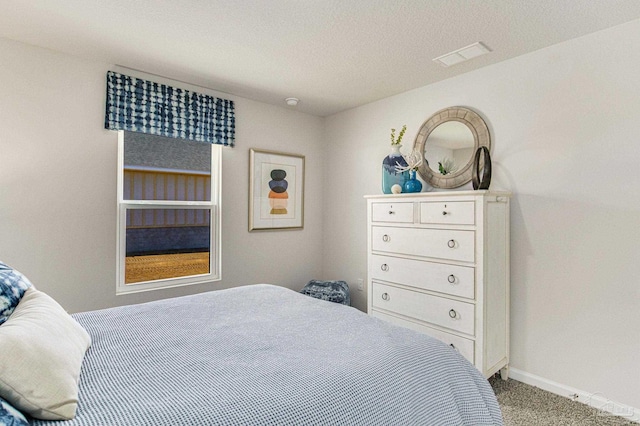 bedroom with a textured ceiling and light carpet