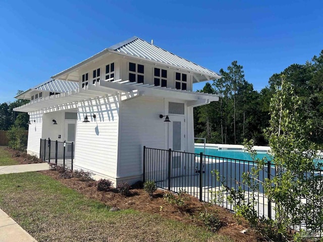 view of side of home featuring a fenced in pool and a pergola