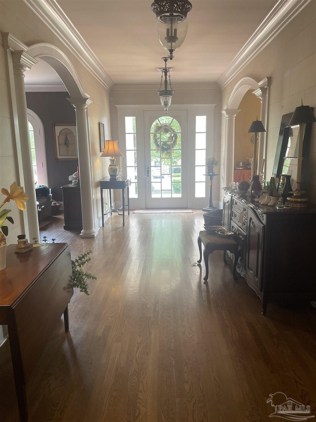 1904 E Larua St, Pensacola, FL 32501 - foyer entrance with decorative columns, arched walkways, wood finished floors, and crown molding