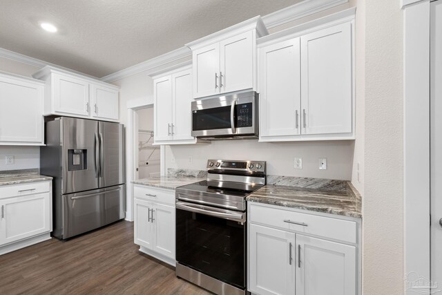 kitchen featuring white cabinetry, stainless steel appliances, ornamental molding, and dark hardwood / wood-style floors