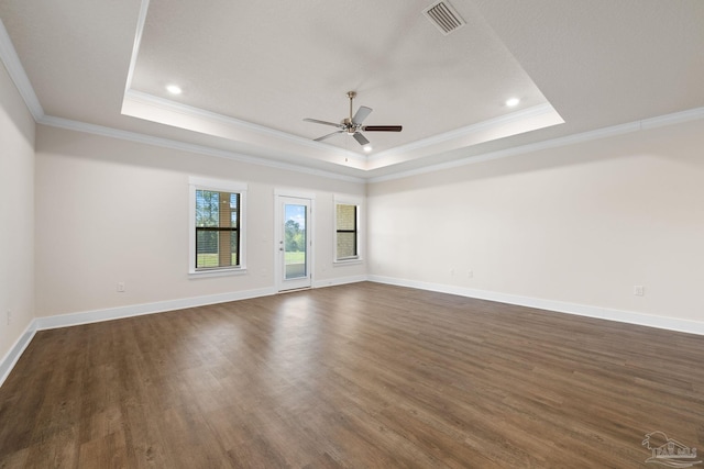 unfurnished room featuring ornamental molding, dark wood-type flooring, and a tray ceiling