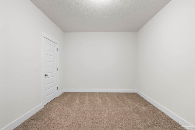 spare room with a textured ceiling and carpet floors