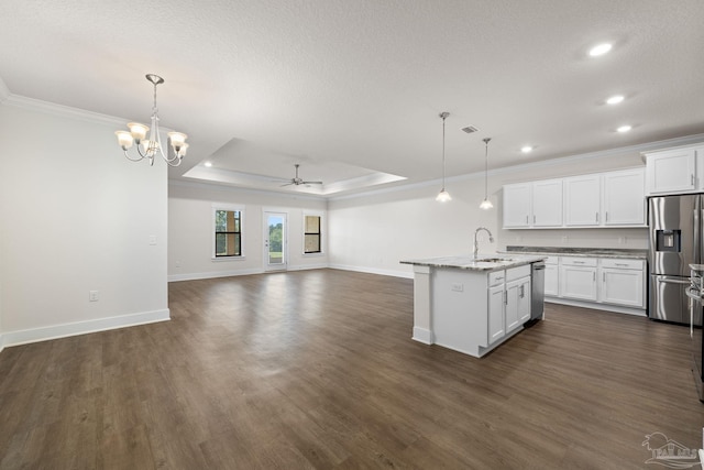 kitchen featuring appliances with stainless steel finishes, an island with sink, white cabinetry, and pendant lighting