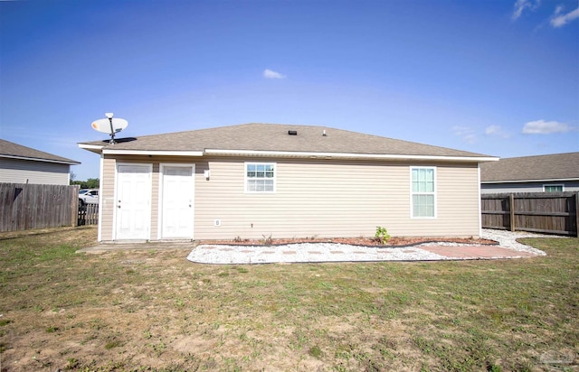 rear view of house featuring a lawn