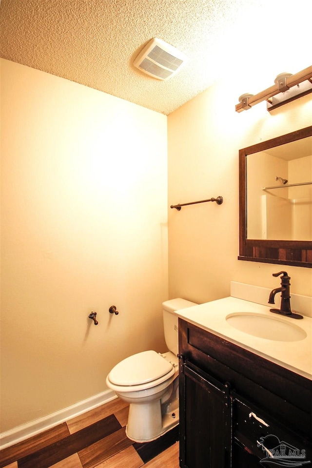 bathroom with a shower, a textured ceiling, toilet, vanity, and hardwood / wood-style flooring