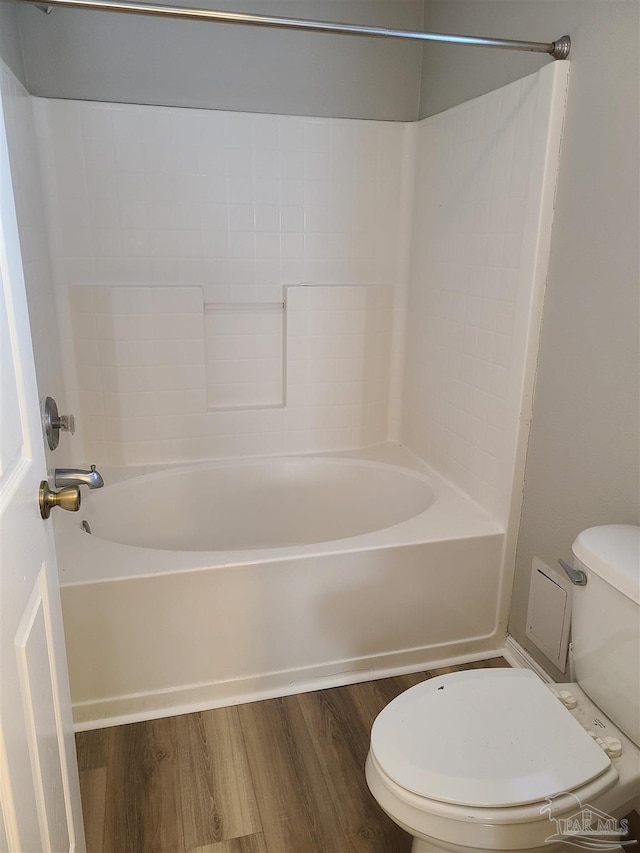 bathroom featuring tub / shower combination, toilet, and wood finished floors