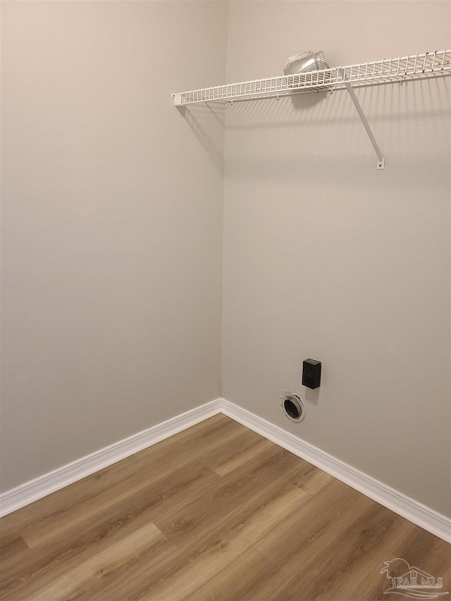 laundry room featuring laundry area, baseboards, and wood finished floors