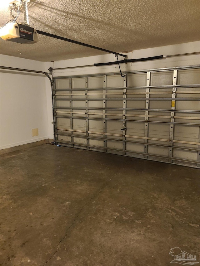 garage featuring a garage door opener and baseboards