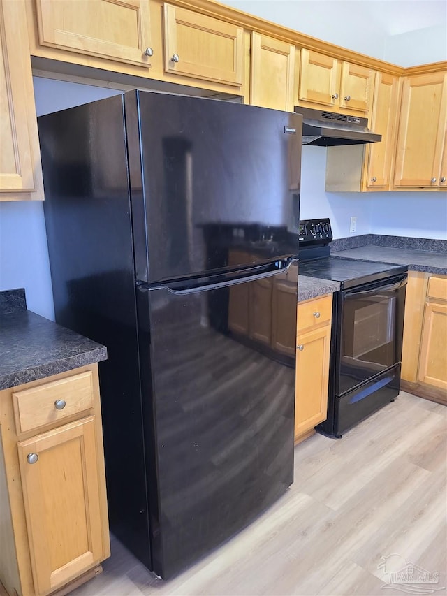 kitchen featuring dark countertops, light brown cabinets, under cabinet range hood, light wood-type flooring, and black appliances