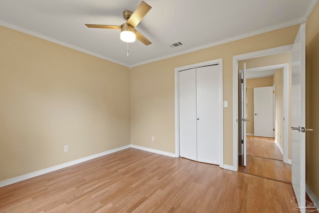 unfurnished bedroom featuring ceiling fan, a closet, light hardwood / wood-style floors, and ornamental molding