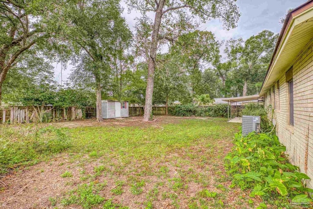 view of yard featuring central AC unit and a storage shed