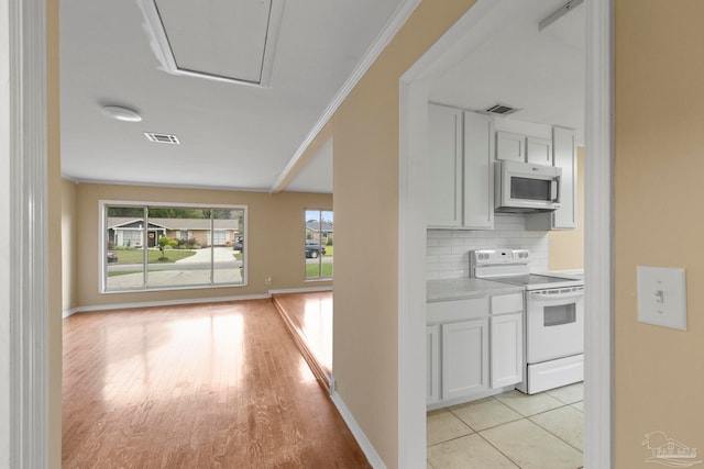 hall with crown molding and light hardwood / wood-style flooring