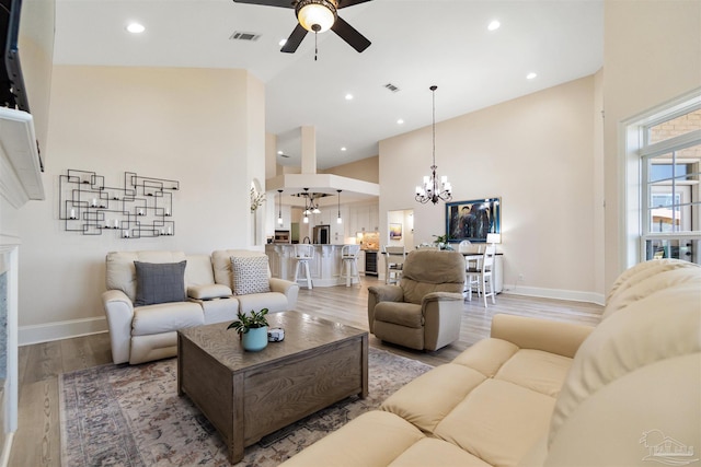 5136 Point Shores Ln, Gulf Breeze, FL 32563 - living area featuring visible vents, high vaulted ceiling, baseboards, ceiling fan with notable chandelier, and light wood finished floors