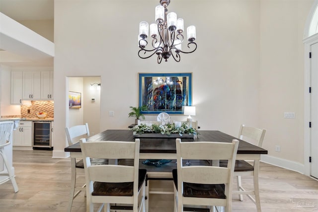5136 Point Shores Ln, Gulf Breeze, FL 32563 - dining room with beverage cooler, baseboards, a notable chandelier, and light wood-type flooring