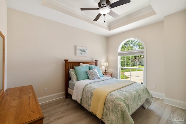 5136 Point Shores Ln, Gulf Breeze, FL 32563 - bedroom with ceiling fan, crown molding, light wood-type flooring, a raised ceiling, and baseboards