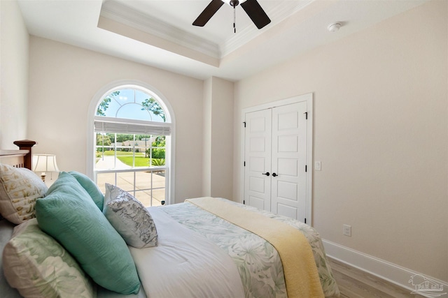 5136 Point Shores Ln, Gulf Breeze, FL 32563 - bedroom with crown molding, wood finished floors, baseboards, a raised ceiling, and a ceiling fan