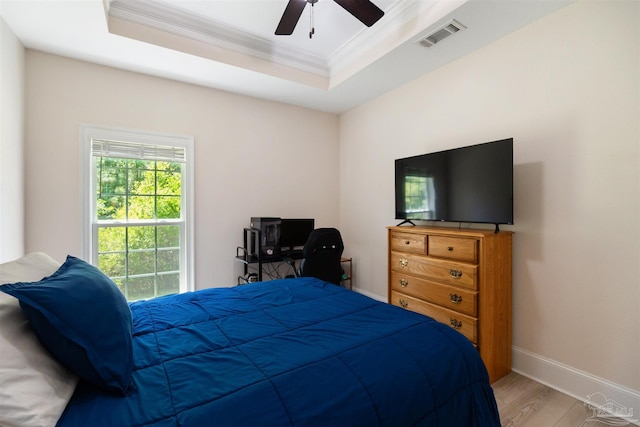 5136 Point Shores Ln, Gulf Breeze, FL 32563 - bedroom with crown molding, baseboards, wood finished floors, a tray ceiling, and visible vents