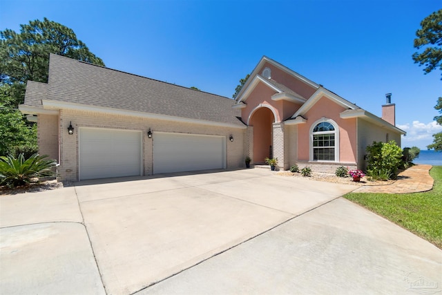 5136 Point Shores Ln, Gulf Breeze, FL 32563 - ranch-style home featuring brick siding, an attached garage, driveway, and a chimney