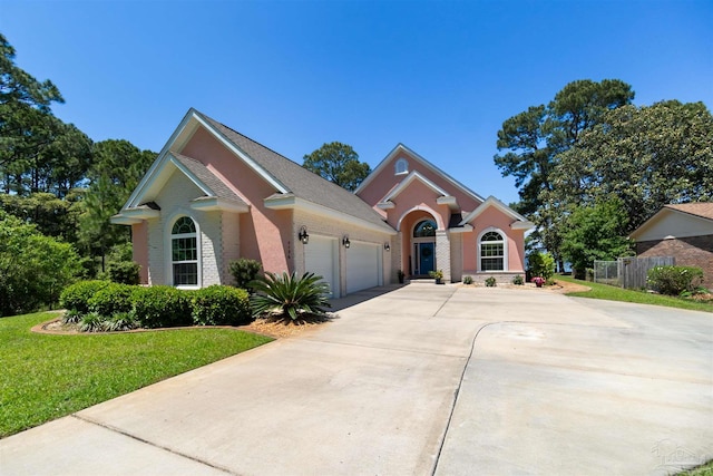 5136 Point Shores Ln, Gulf Breeze, FL 32563 - view of front facade with a garage, brick siding, fence, a front lawn, and concrete driveway