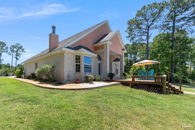 5136 Point Shores Ln, Gulf Breeze, FL 32563 - view of home's exterior featuring a lawn, brick siding, a chimney, and a wooden deck