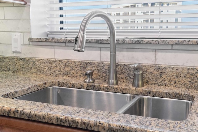 details with a sink and decorative backsplash