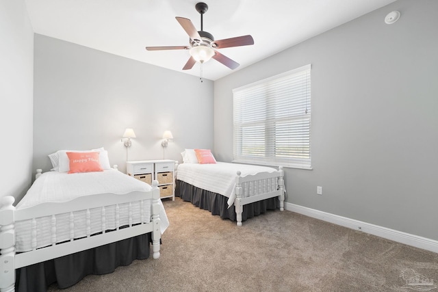 bedroom featuring a ceiling fan, light carpet, and baseboards