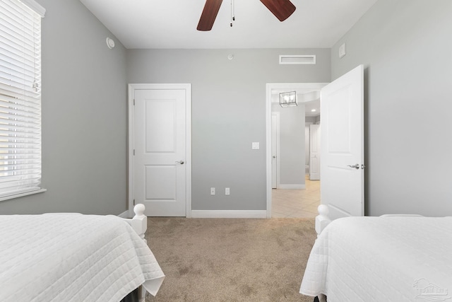 bedroom featuring light carpet, ceiling fan, visible vents, and baseboards