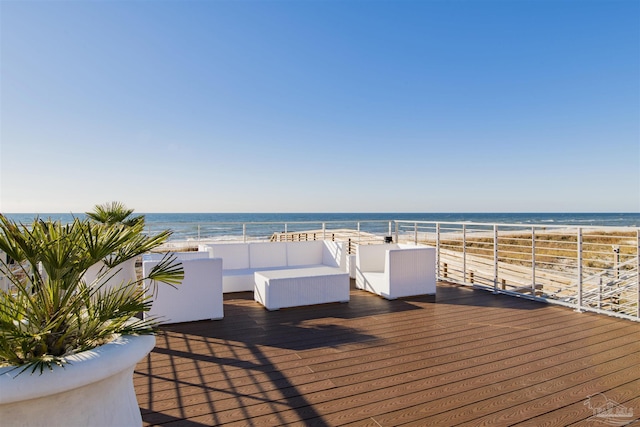 wooden terrace featuring a water view, outdoor lounge area, and a view of the beach